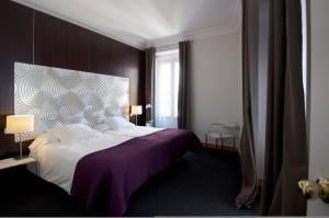 sypialnia z dużym łóżkiem i fioletowym kocem w obiekcie Suite Prado w Madrycie
