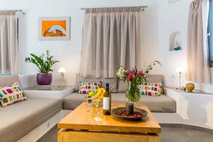 un soggiorno con divano e tavolo di Aspronisi Luxury Villa with Caldera View a Megalochori