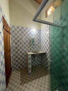 a bathroom with a sink and a glass shower at Casa na lagoa azul in Cruz