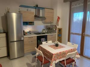 a kitchen with a table and a stainless steel refrigerator at OnlyRoomsRho in Rho