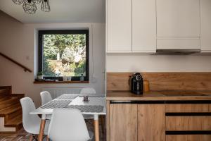 een keuken met een tafel en stoelen en een raam bij Dom na Gazownikow12 in Brenna