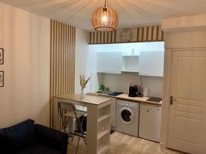 a kitchen with a table and a washing machine at Agréable 2 pièces à Pantin in Pantin