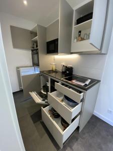 a kitchen with white cabinets and a black counter top at 4-Living Apartment Houses in Nuremberg