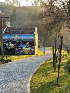 un capanno giallo con un dipinto sul lato di NATURE e SPA AL - Termas Saúde e Beleza, Totalmente Renovado - Piscinas Municipais em frente - Epoca Julho a Setembro a São Pedro do Sul