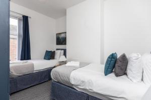 1 Schlafzimmer mit 2 Betten und einem Fenster in der Unterkunft Cosy two bedroom property! in Featherstone