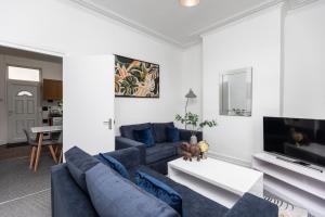 a living room with a blue couch and a tv at Cosy two bedroom property! in Featherstone