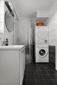 y baño con lavadora y lavamanos. en Vetteberget Lagenheten, en Fjällbacka