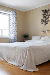 1 cama blanca en un dormitorio con ventana en Vetteberget Lagenheten en Fjällbacka