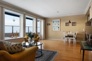 a living room with chairs and a table and windows at Seafront with Terrific View by AJF Dream Living in Fjällbacka