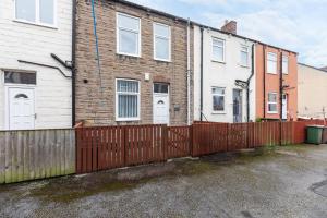 a house with a red fence in front of it at Cosy two bedroom property! in Featherstone