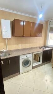 a kitchen with a washing machine and a sink at Nador Holidays in Nador