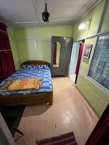 ein Schlafzimmer mit einem Bett in der Ecke eines Zimmers in der Unterkunft Hemalata Heritage Home in Guwahati