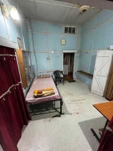 une chambre avec un lit dans une chambre aux murs bleus dans l'établissement Hemalata Heritage Home, à Guwahati