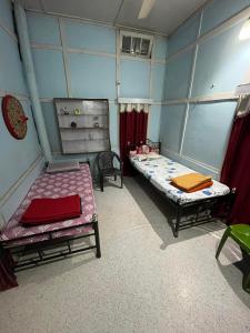Zimmer mit 2 Betten in einem Zimmer in der Unterkunft Hemalata Heritage Home in Guwahati