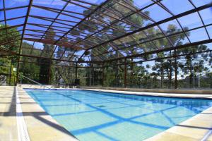 una gran piscina con techo de cristal en Hotel Vila Inglesa, en Campos do Jordão