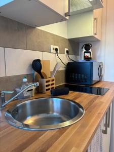 eine Küchentheke mit Spüle und Mikrowelle in der Unterkunft L'escale, Studio proche Gare Melun avec parking privé in Dammarie-les-Lys + 7 Fotos