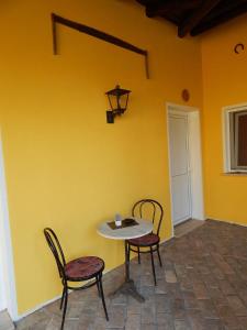 a table and chairs in a room with a yellow wall at B&B Corte Bolandina in Taglio di Po