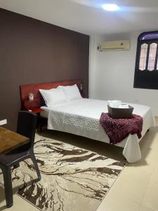 a bedroom with a bed and a table and a chair at Casa Mar Riohacha in Ríohacha