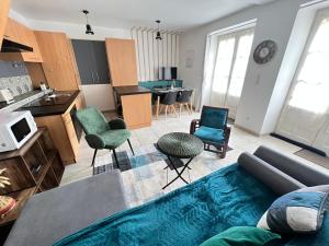 ein Wohnzimmer mit einem Sofa und Stühlen sowie eine Küche in der Unterkunft Maison La Madeleine hyper centre in Vendôme