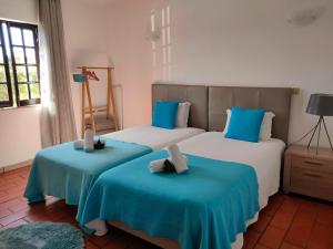two beds in a room with blue and white at Vicentina Rooms by Casas do Alentejo in Almograve
