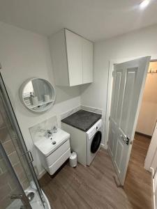 a small bathroom with a sink and a washing machine at Riverview Apartment, Inverness in Inverness