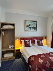 een slaapkamer met een bed met een rood hoofdeinde bij Hotel Skandia in Helsingør