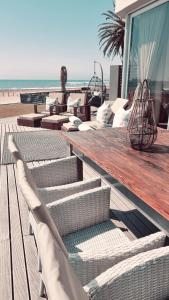 a deck with chairs and tables on the beach at Oceana View in Swakopmund