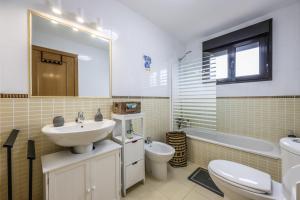 een badkamer met een wastafel, een toilet en een bad bij Blue Star Villa in Lajares +23 foto's