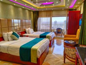 um quarto de hotel com duas camas e uma varanda em Nile Vibes Hotel no Cairo