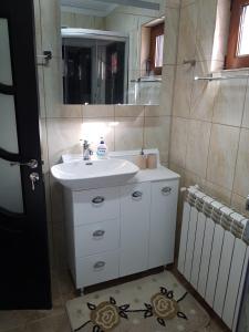 y baño con lavabo blanco y espejo. en Casa Nicolas Busteni en Buşteni