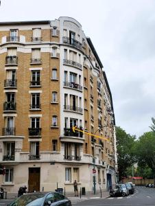 a tall building with cars parked in front of it at Bel appartement à Clichy sur Seine in Clichy