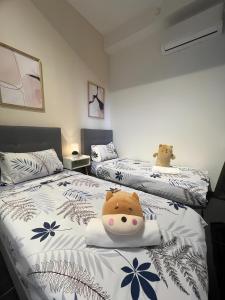 a bedroom with two beds with stuffed animals on them at Urban Suites by PerfectSweetHome with Home Feel L in Jelutong