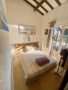 um pequeno quarto com uma cama e uma varanda em Très bel appartement les pieds dans l’eau em Appietto
