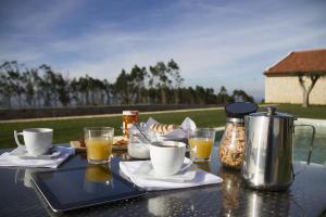 einen Tisch mit Kaffeekanne und Gläsern darauf in der Unterkunft Casa da Serra in Arrimal