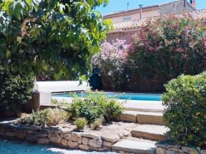 un jardín con un banco junto a una piscina en Villa Catharissima, piscine privee, en Blomac