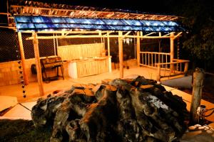 a fire pit in a backyard with a roof at Hotel Don Bululo Camping Lodge in Punta Rucia