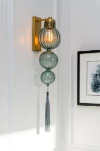 a glass lamp with a tassel hanging on a wall at RÌGH Residences - George Street in Edinburgh