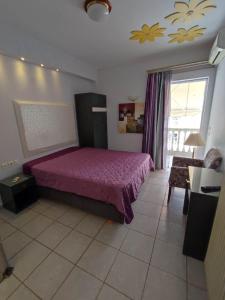 ein Schlafzimmer mit einem lila Bett in einem Zimmer in der Unterkunft Villa Niki in Olympiakí Aktí