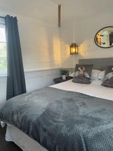 a bedroom with a bed and a mirror on the wall at The Gatehouse in Long Melford
