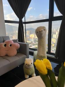 three stuffed animals sitting in front of a window at Urban Suites by PerfectSweetHome with Home Feel L in Jelutong