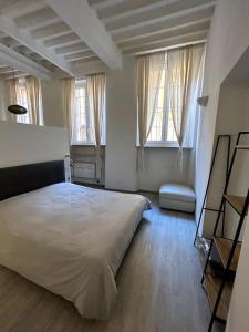 een slaapkamer met een wit bed en 2 ramen bij Splendido Loft Centro Storico Parma in Parma