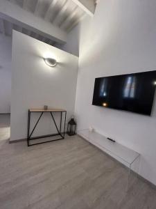 een kamer met een grote flatscreen-tv aan de muur bij Splendido Loft Centro Storico Parma in Parma