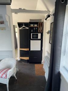 a room with a kitchen with a microwave and a door at The Gatehouse in Long Melford