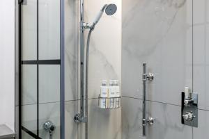 W łazience znajduje się prysznic ze szklanymi drzwiami. w obiekcie RÌGH Residences - George Street w Edynburgu
