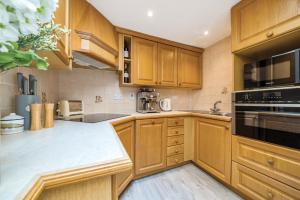 a kitchen with wooden cabinets and a stove top oven at N ° 42 The Salcombe in Salcombe