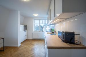 een keuken met witte muren en een aanrecht bij CoView - ruhige Design Wohnung - 2 Schlafzimmer - voll ausgestattete Küche in Dresden