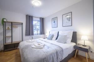 ein Schlafzimmer mit einem großen weißen Bett und einem Fenster in der Unterkunft CoView - ruhige Design Wohnung - 2 Schlafzimmer - voll ausgestattete Küche in Dresden