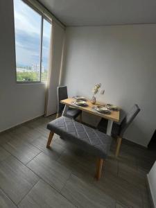 a dining room table and chair with a table and a window at Apartamento completo en Pereira. in Pereira