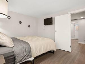 Un dormitorio con una cama y un televisor en la pared. en Elegant Richmond Gem nestled up to Hawthorne Blvd., en Portland