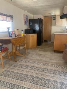 a kitchen with a table and a black refrigerator at Park Model Furnished #5 in Tucson +3 photos